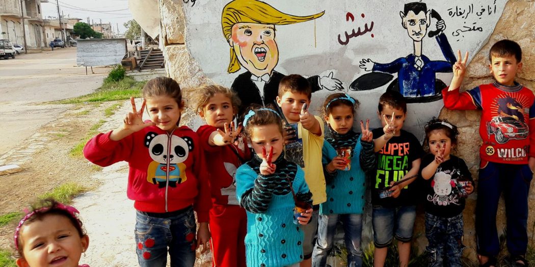 أطفال في مدينة بنش أمام رسم للسخرية من ضربة ترامب
