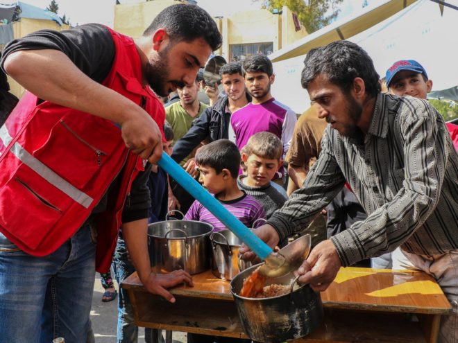 الهلال الأحمر يوزع الطعام في مركز للإيواء بعدرا